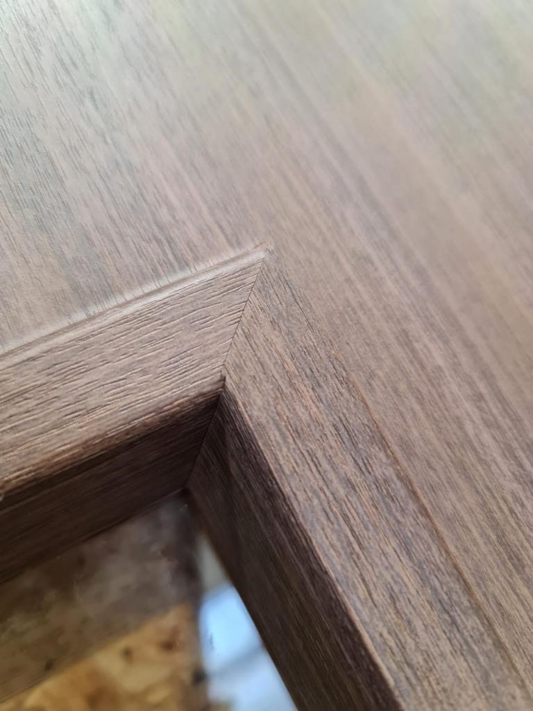 Close up of grey woodgrain vinyl wrapped office door joint